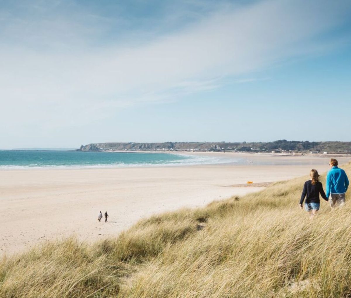 Couple walking along St. Ouens Bay, Jersey