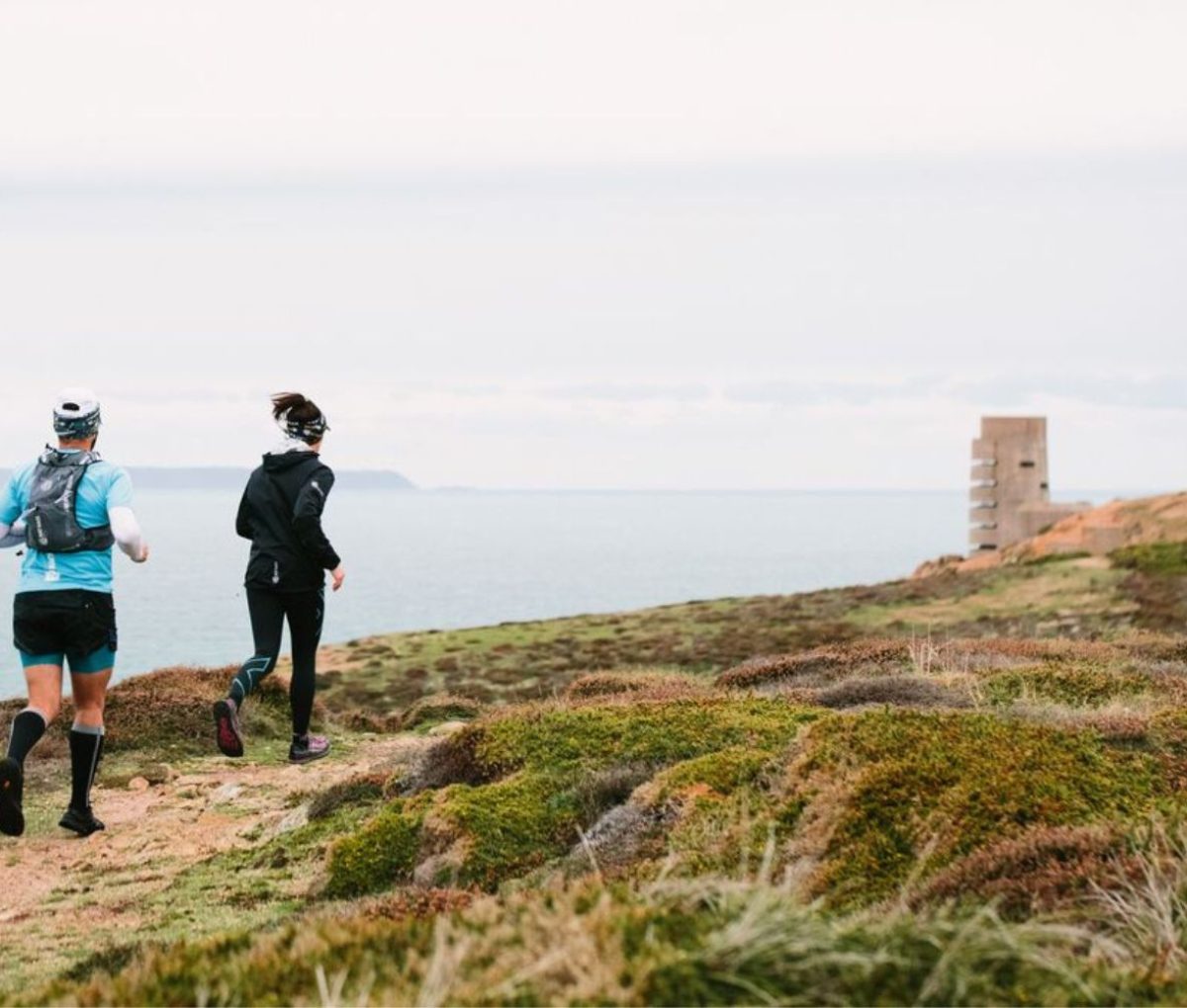 Two runners running along the north coast, Jersey